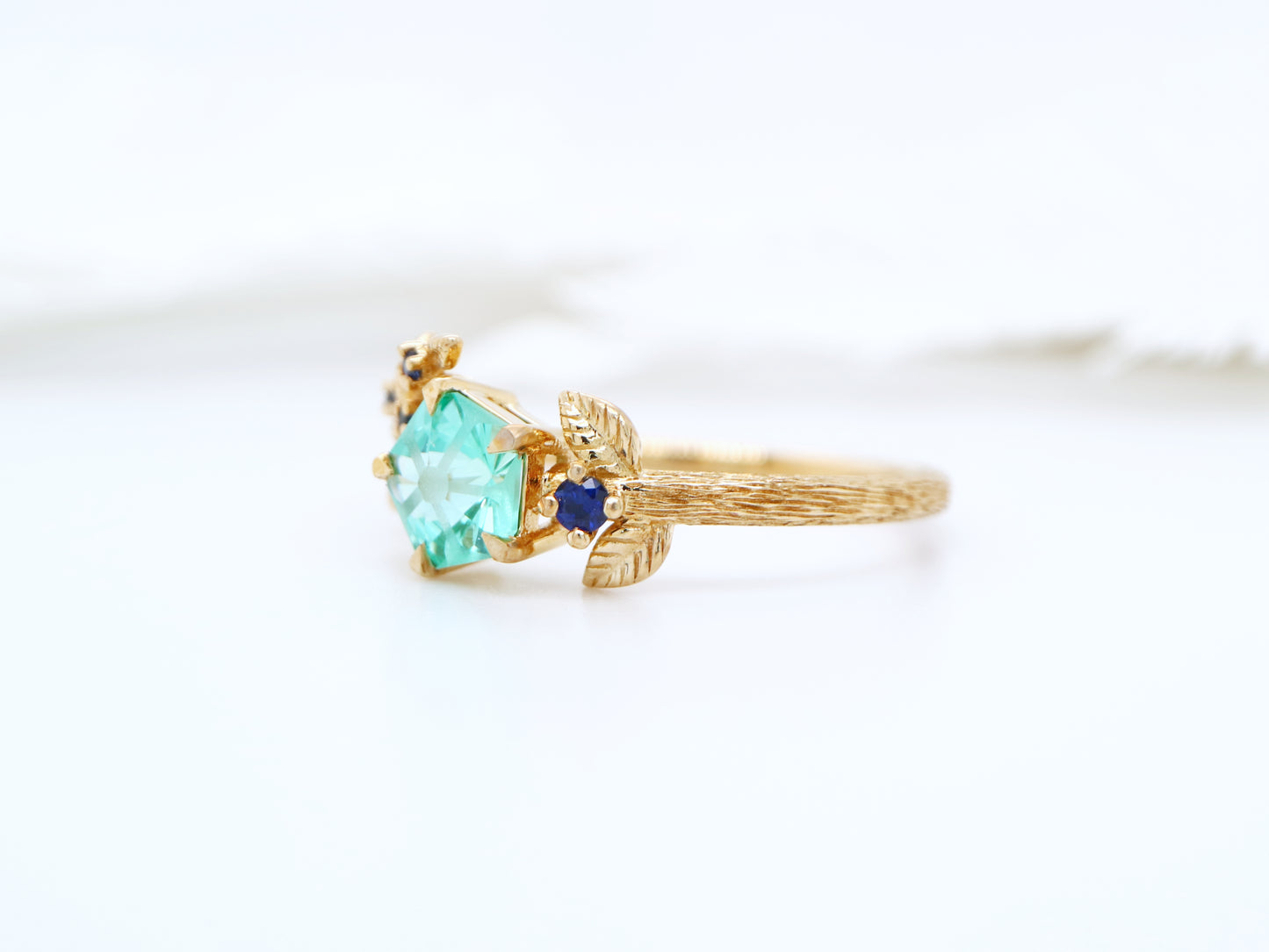 Teal sapphire Hanami ring set in golden leaf and twig design