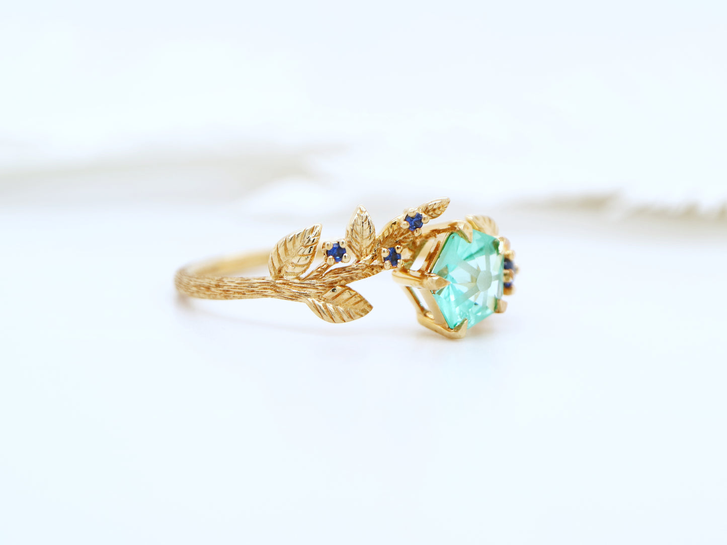 Teal sapphire Hanami ring set in golden leaf and twig design