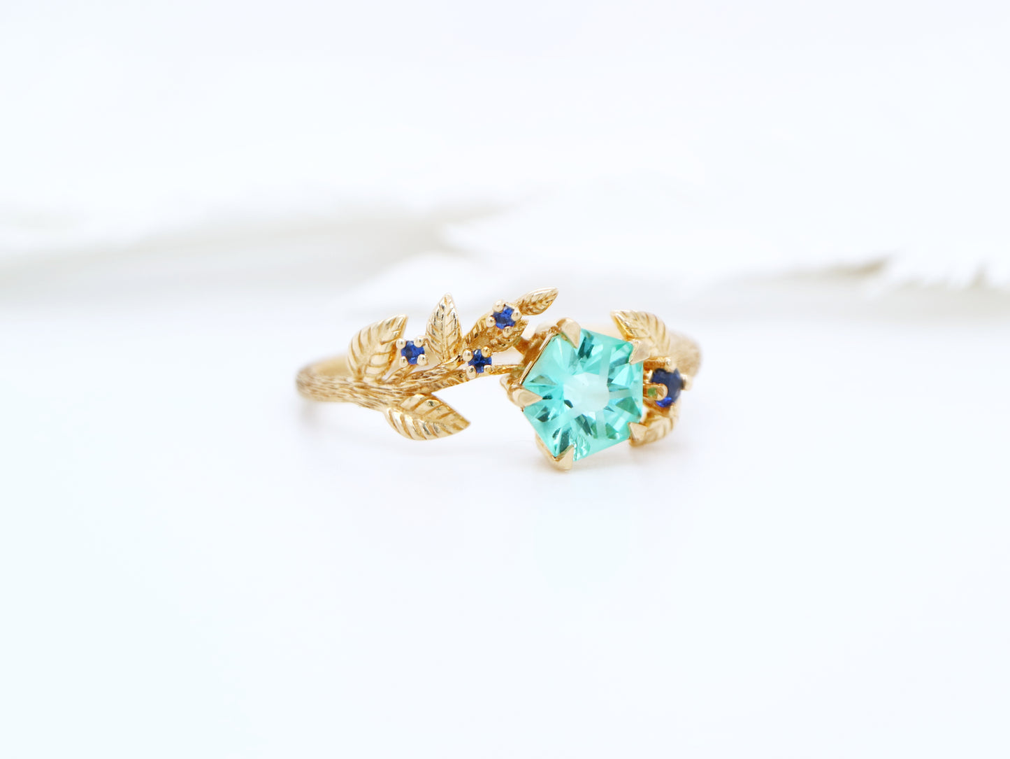 Teal sapphire Hanami ring set in golden leaf and twig design