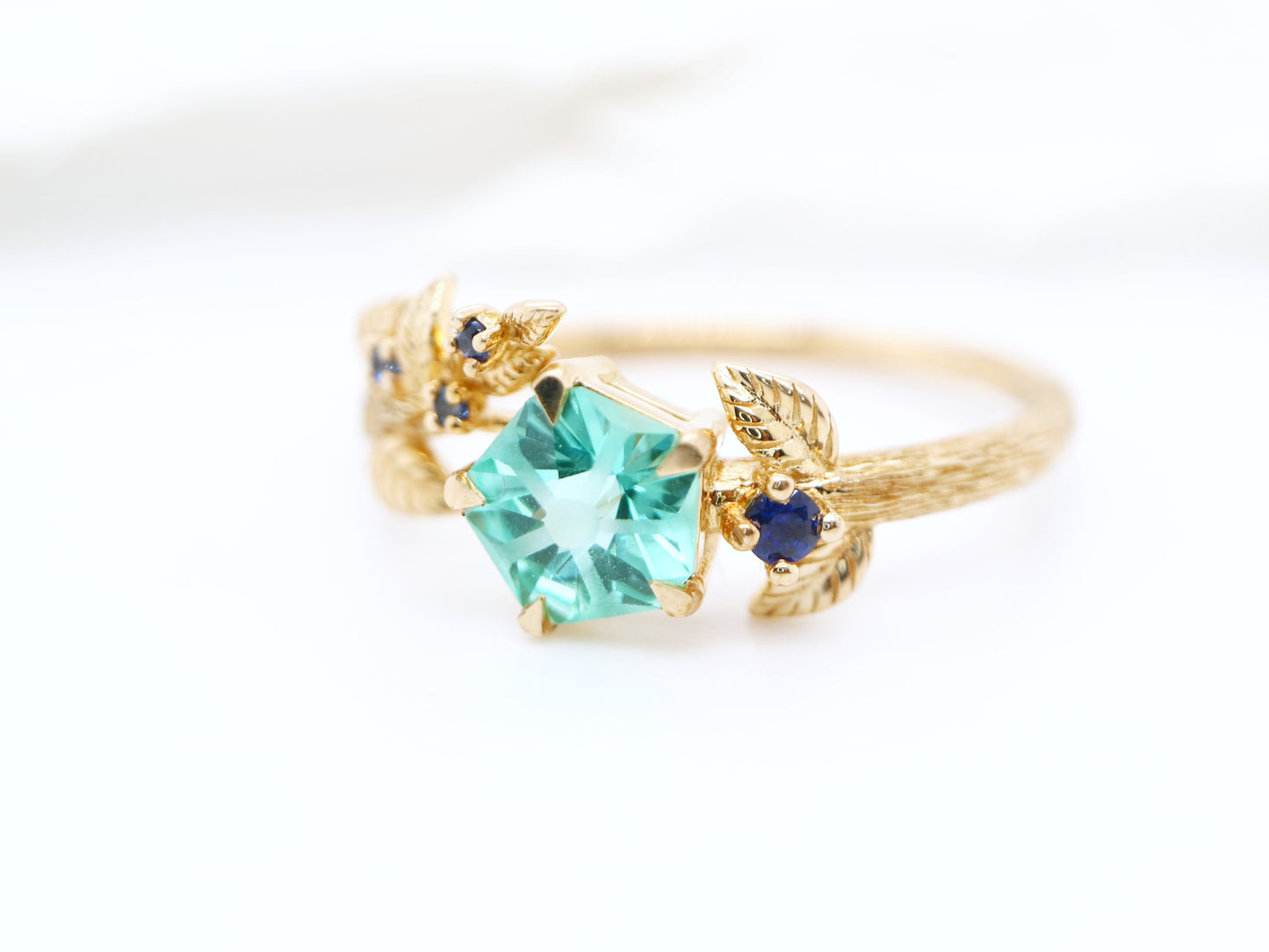 Teal sapphire Hanami ring set in golden leaf and twig design