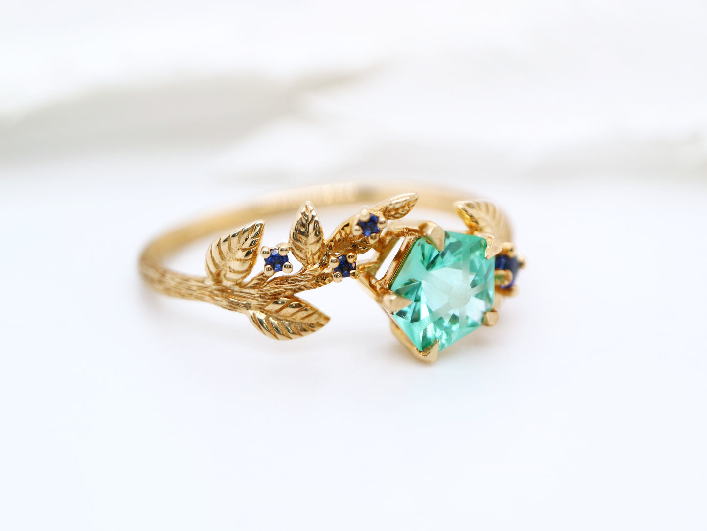 Teal sapphire Hanami ring set in golden leaf and twig design