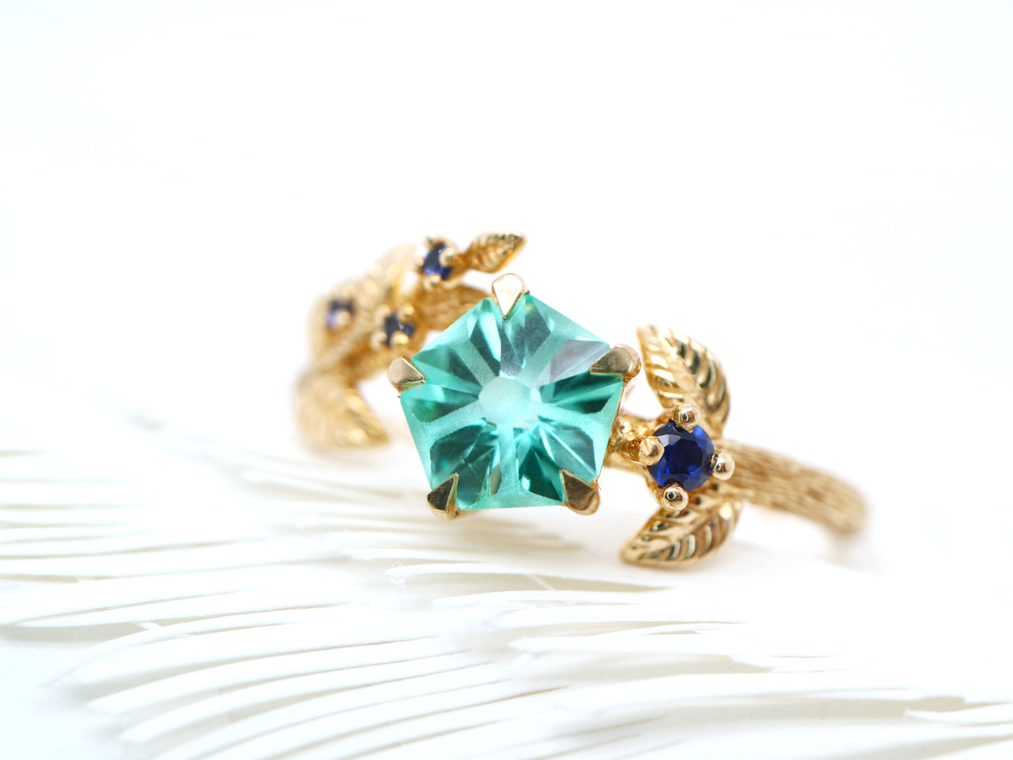 Teal sapphire Hanami ring set in golden leaf and twig design