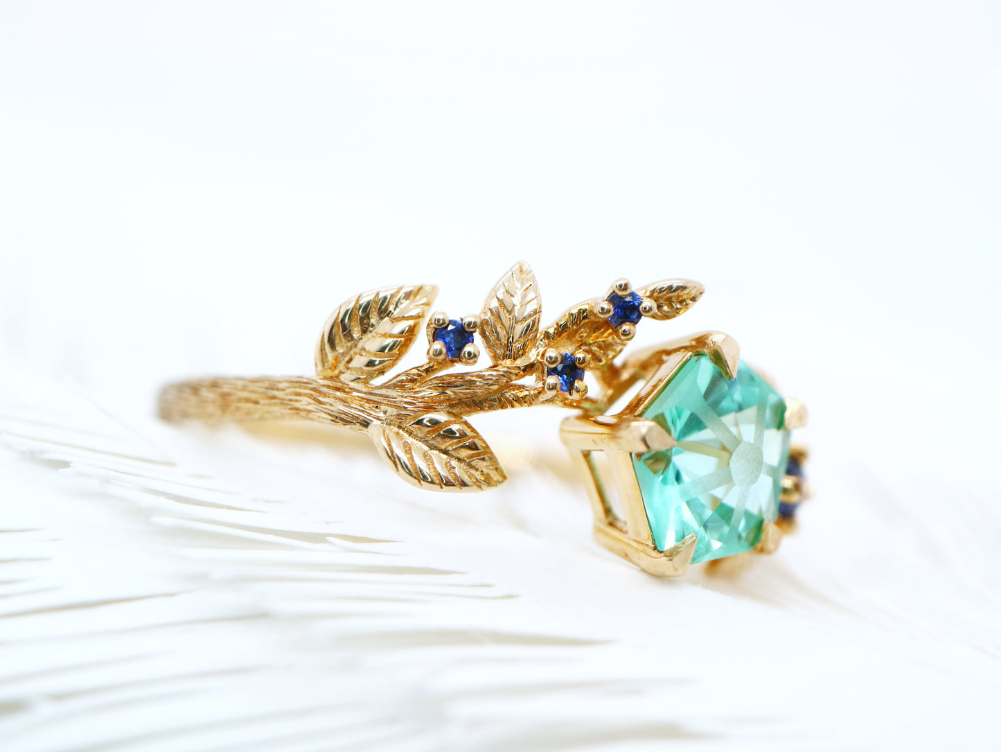 Teal sapphire Hanami ring set in golden leaf and twig design