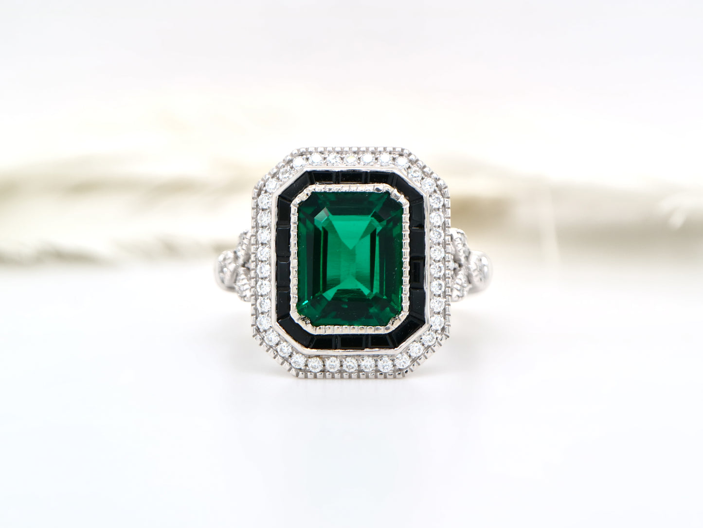 Art deco style emerald ring with black onyx channel set halo