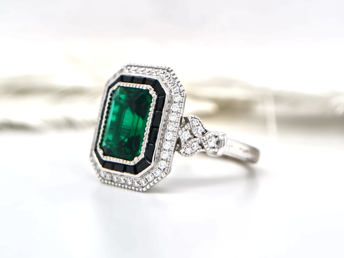 Art deco style emerald ring with black onyx channel set halo