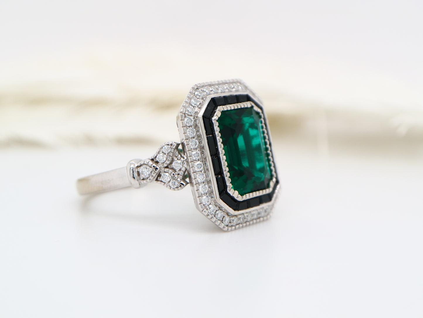 Art deco style emerald ring with black onyx channel set halo