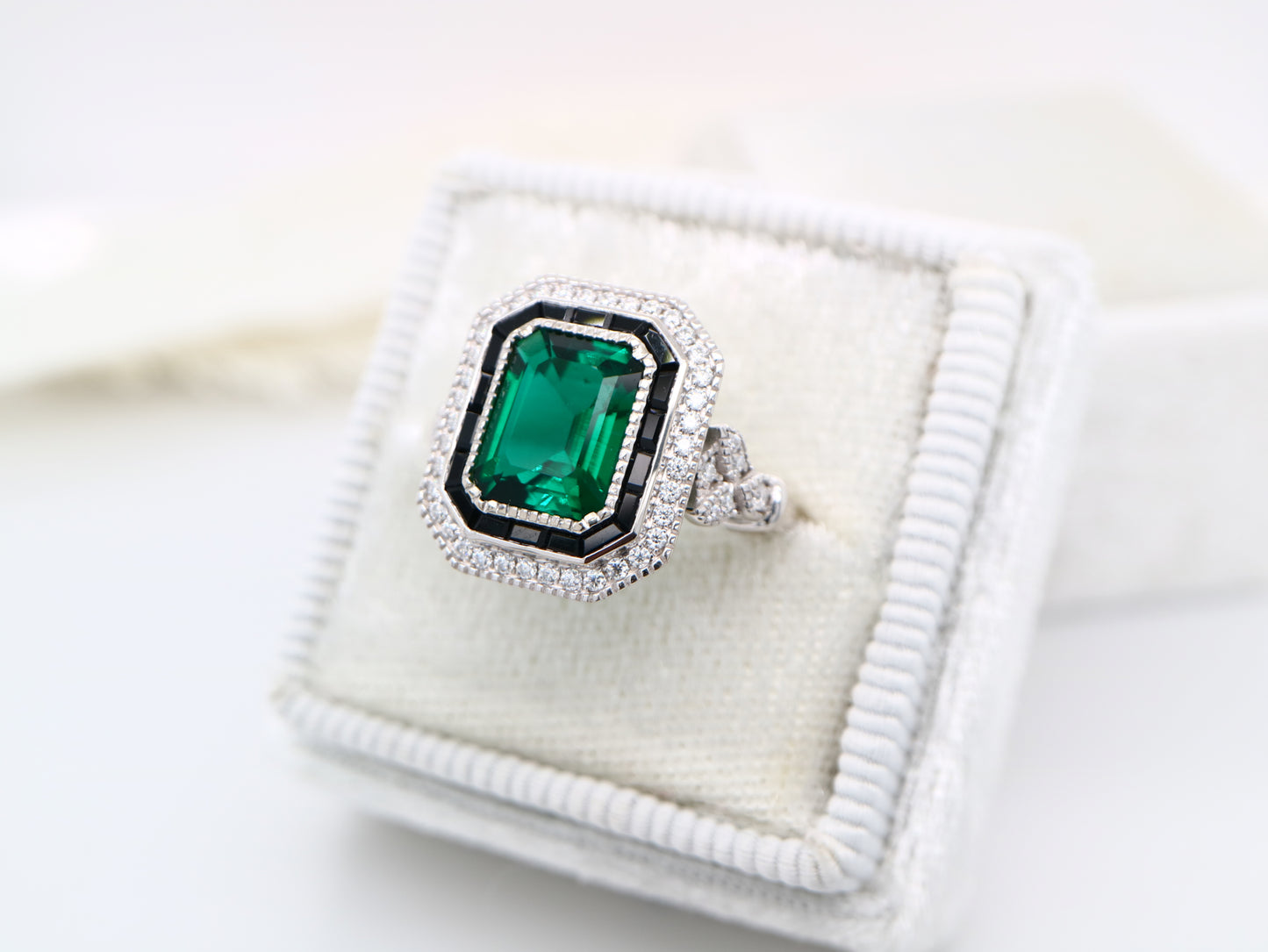 Art deco style emerald ring with black onyx channel set halo