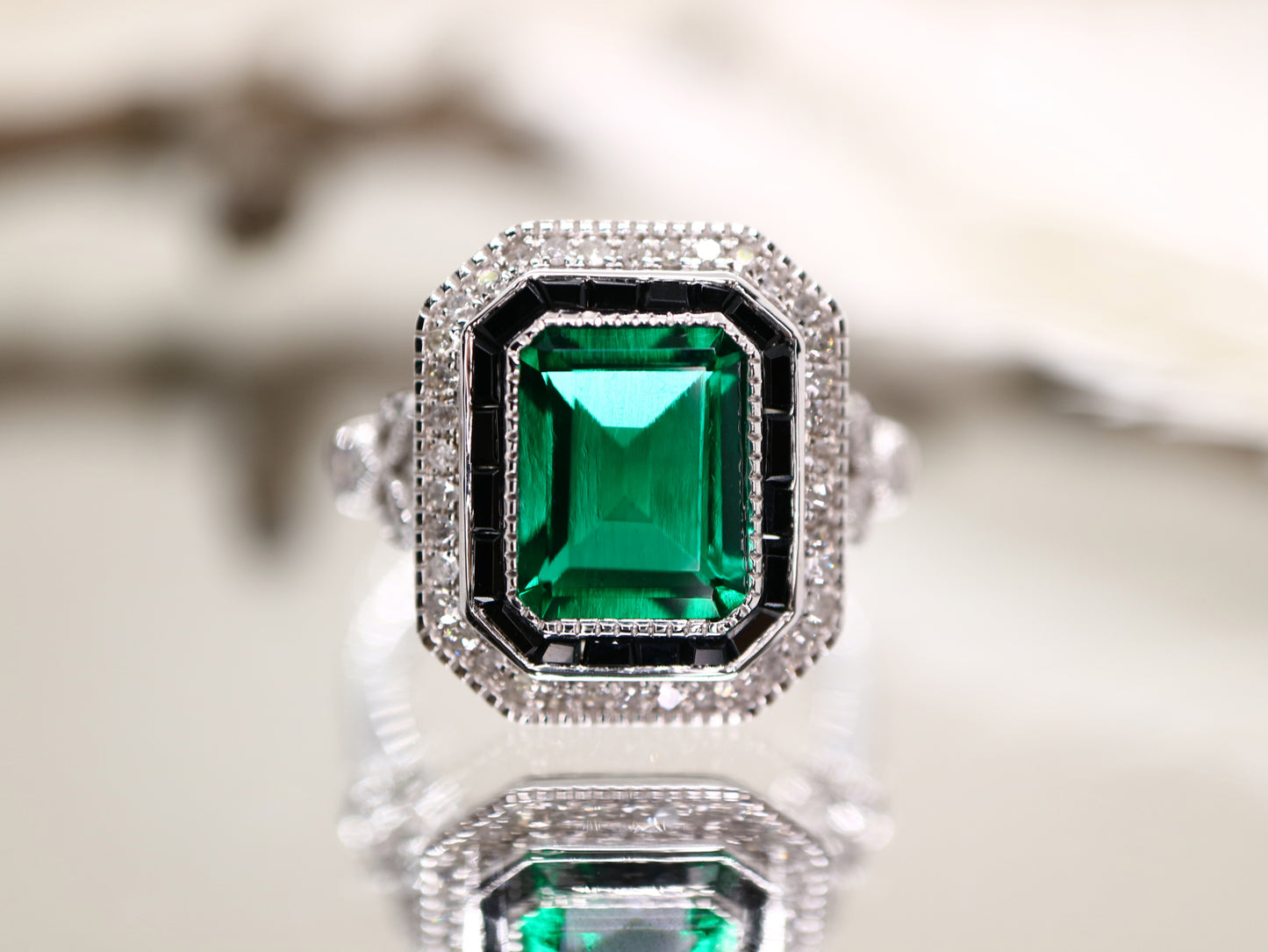 Art deco style emerald ring with black onyx channel set halo