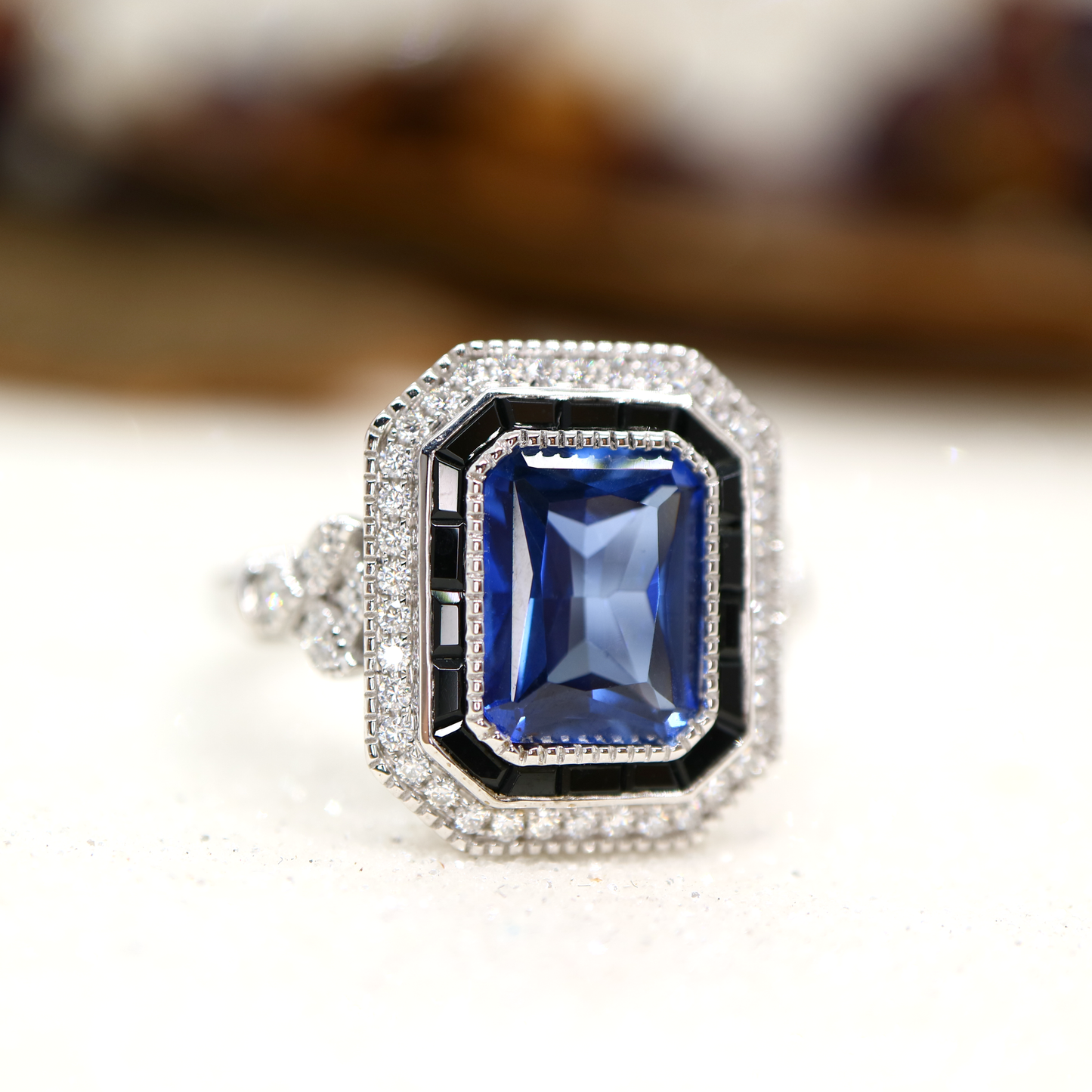 Art deco style blue sapphire ring with black onyx channel set halo