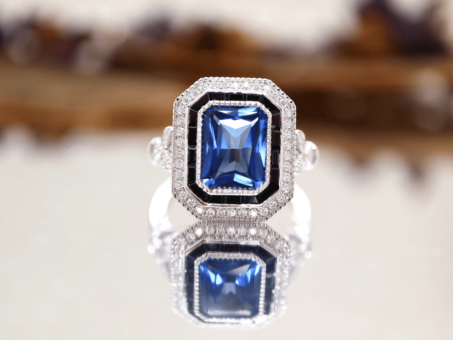 Art deco style blue sapphire ring with black onyx channel set halo