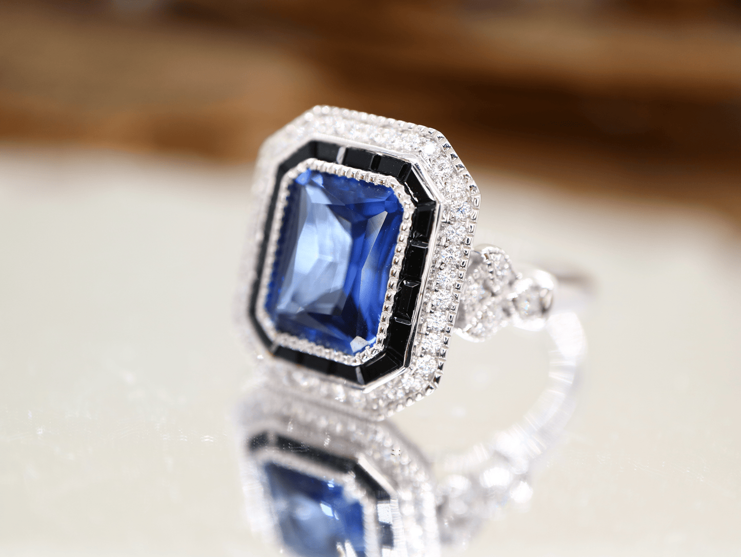 Art deco style blue sapphire ring with black onyx channel set halo