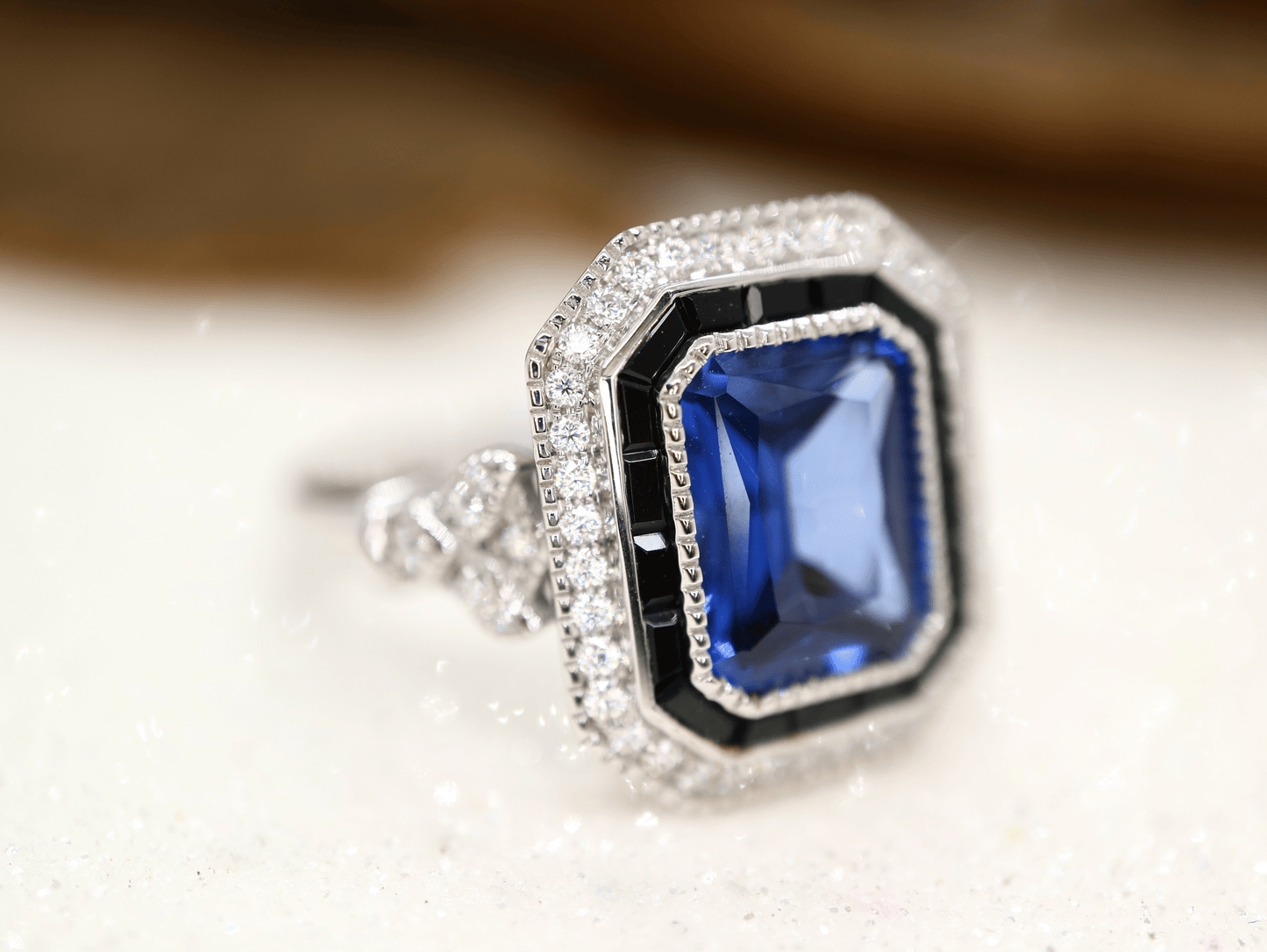 Art deco style blue sapphire ring with black onyx channel set halo