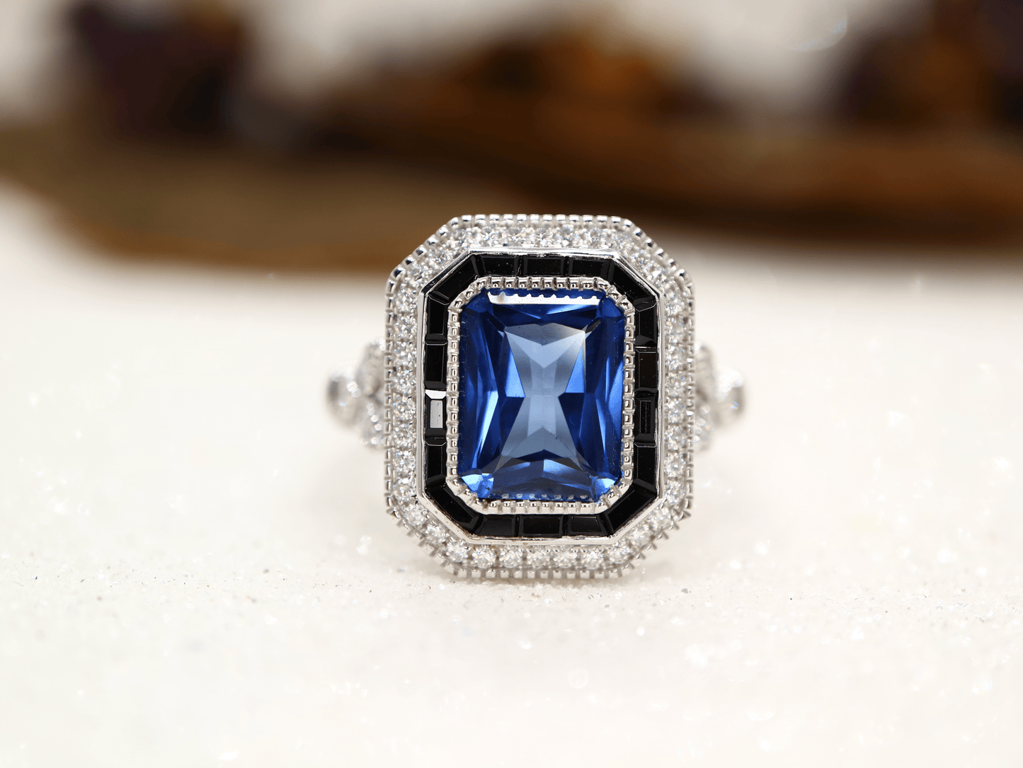 Art deco style blue sapphire ring with black onyx channel set halo