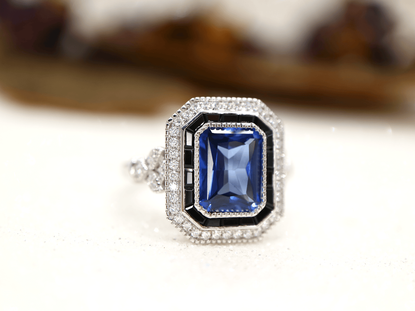 Art deco style blue sapphire ring with black onyx channel set halo