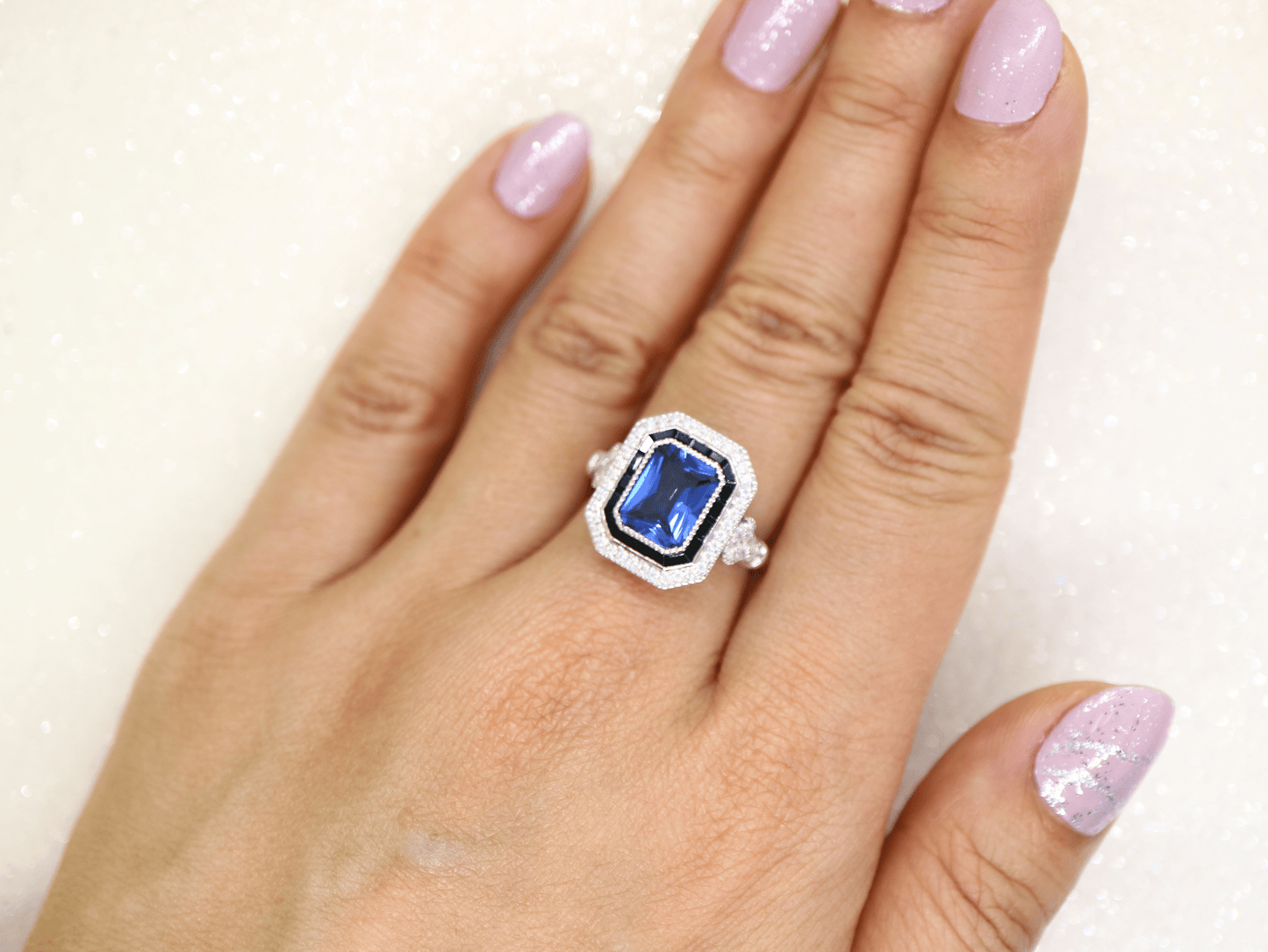 Art deco style blue sapphire ring with black onyx channel set halo